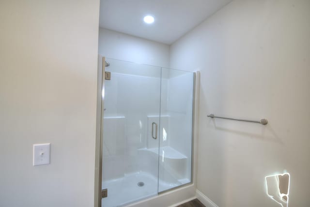 full bath featuring a shower stall and baseboards