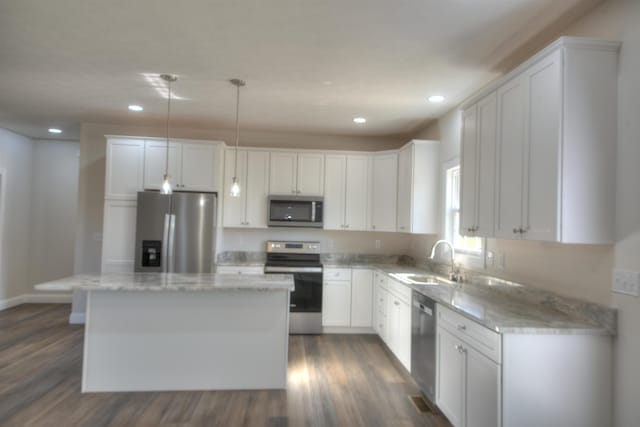 kitchen with appliances with stainless steel finishes, white cabinets, and a center island