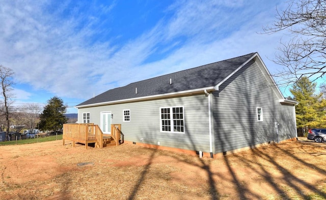 rear view of house with crawl space, driveway, and a shingled roof