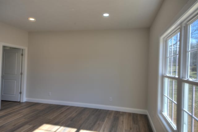 spare room with dark wood-type flooring, recessed lighting, and baseboards