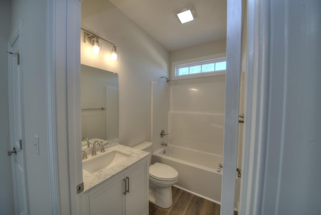 bathroom with toilet, bathtub / shower combination, wood finished floors, and vanity