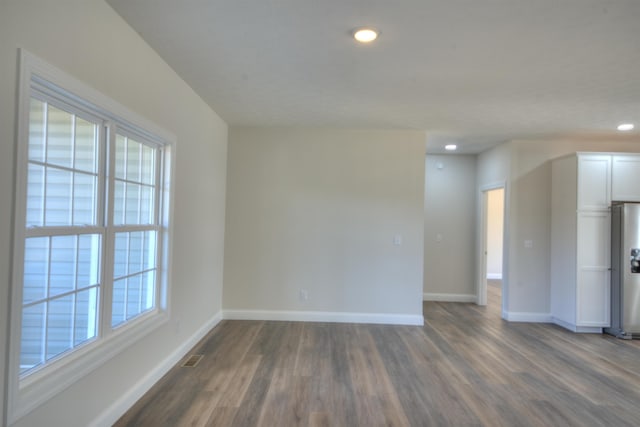 spare room featuring recessed lighting, visible vents, dark wood finished floors, and baseboards