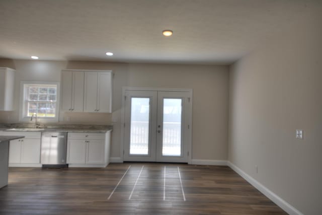 kitchen with dishwasher, french doors, white cabinetry, and baseboards