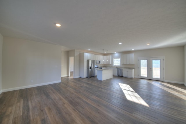 unfurnished living room with recessed lighting, a sink, baseboards, french doors, and dark wood finished floors