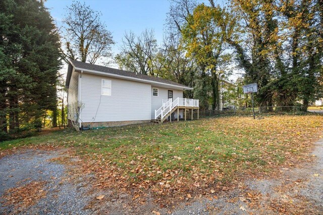 rear view of house with a yard and a deck