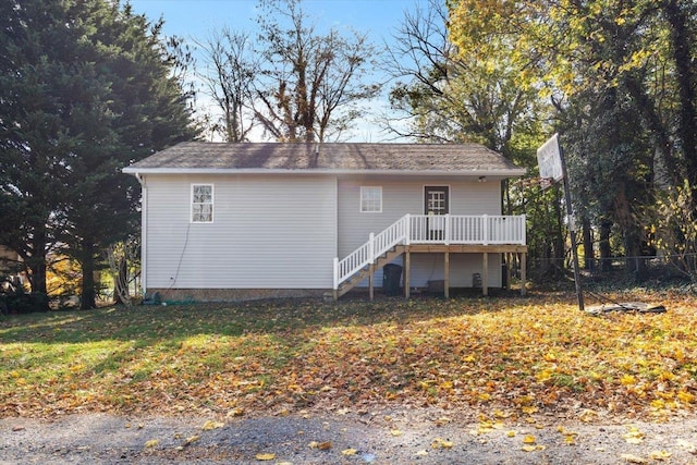 rear view of property with a wooden deck and a yard