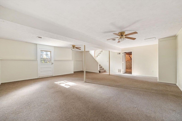 basement featuring ceiling fan, carpet flooring, and a textured ceiling