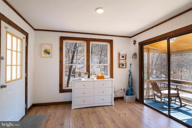 doorway to outside featuring light wood-type flooring, crown molding, and baseboards