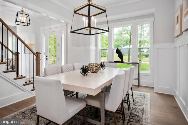 dining space with dark wood finished floors, plenty of natural light, and an inviting chandelier