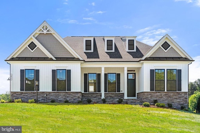 view of front of house with stone siding, metal roof, a standing seam roof, board and batten siding, and a front yard