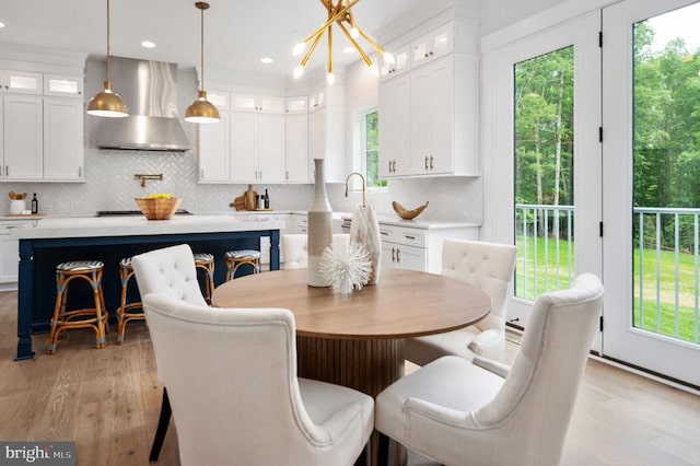 dining room with light wood finished floors, recessed lighting, and a notable chandelier