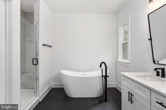 full bathroom with a soaking tub, a marble finish shower, vanity, and baseboards