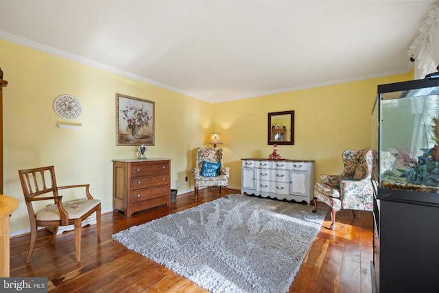 living area with crown molding and hardwood / wood-style floors