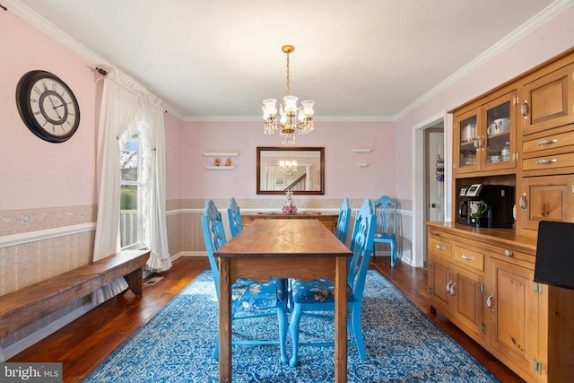 dining area with an inviting chandelier, ornamental molding, dark hardwood / wood-style flooring, and sink