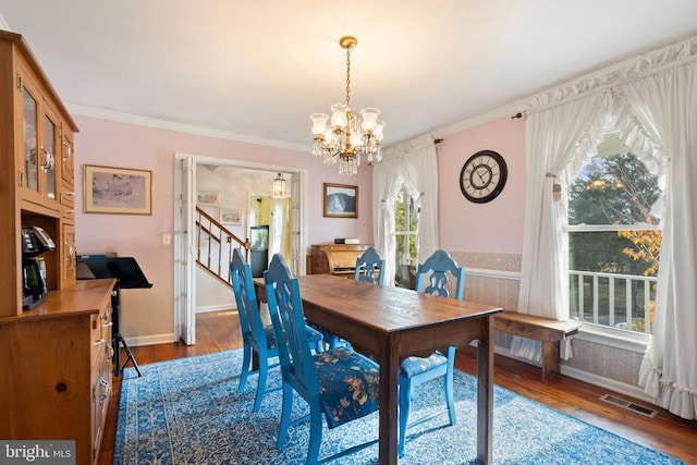 dining area with a notable chandelier, crown molding, and dark hardwood / wood-style floors