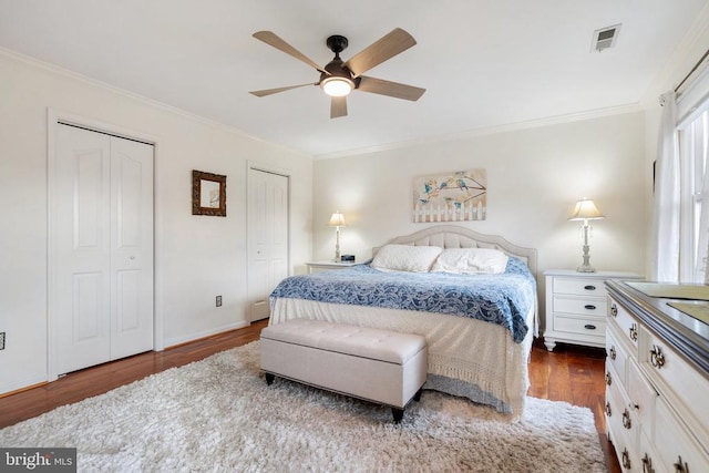 bedroom featuring wood-type flooring, two closets, and crown molding