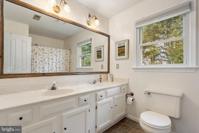 bathroom with a shower with curtain, tile patterned floors, vanity, and toilet