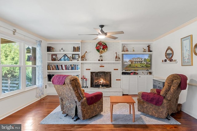 living room with built in shelves, ornamental molding, wood-type flooring, and a fireplace