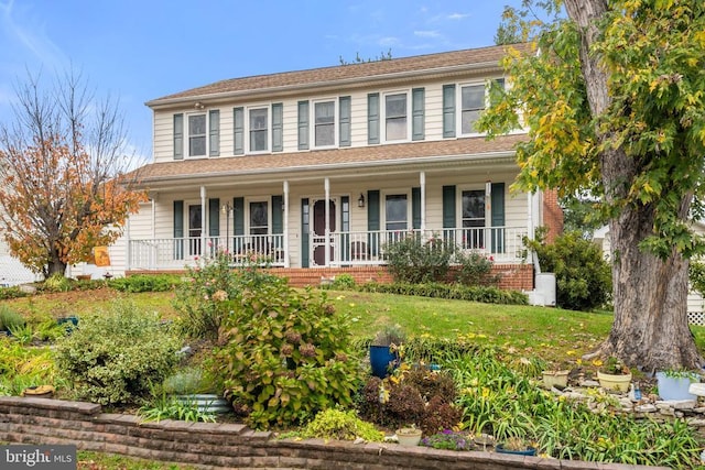 view of front of property with a porch and a front lawn