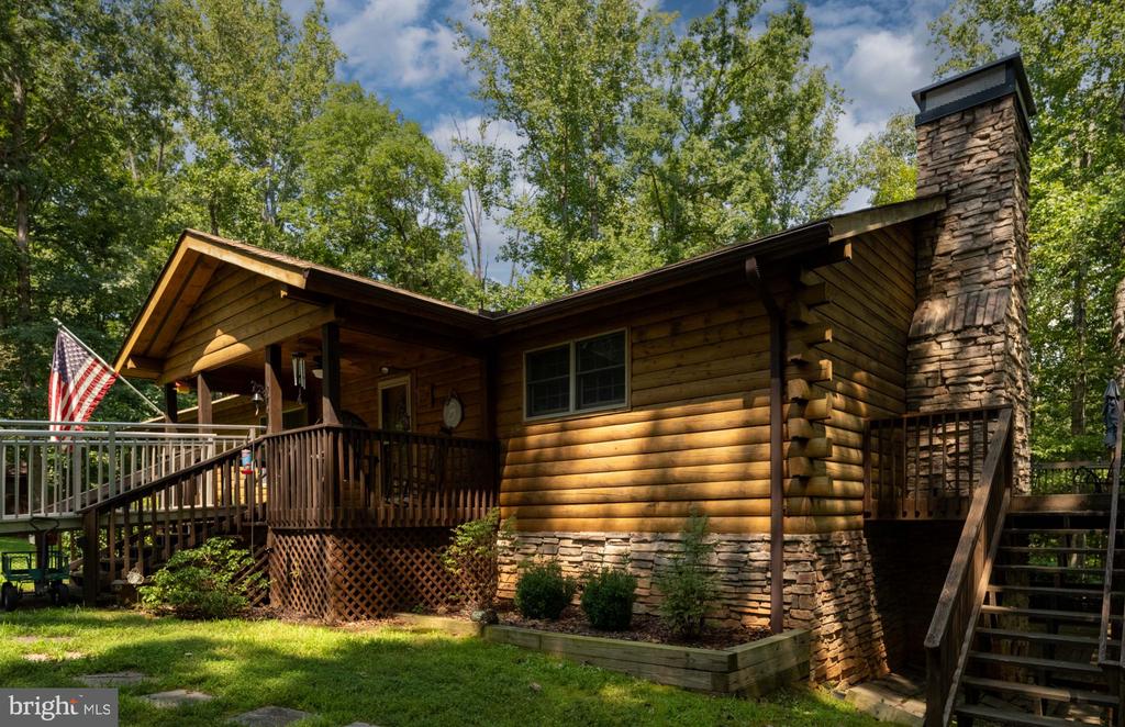 rear view of house with a wooden deck and a yard