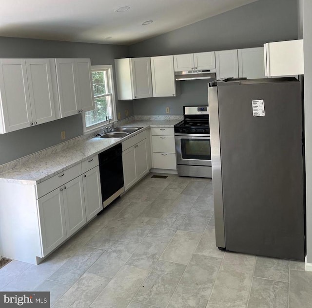 kitchen with lofted ceiling, sink, stainless steel appliances, light stone countertops, and white cabinets