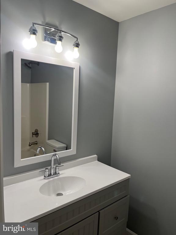 full bathroom featuring shower / washtub combination, toilet, and vanity