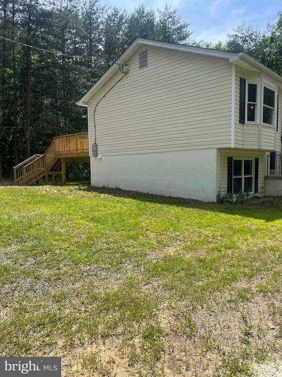 view of side of home featuring a yard and a deck