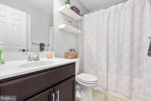 bathroom with toilet, vanity, and tile patterned floors