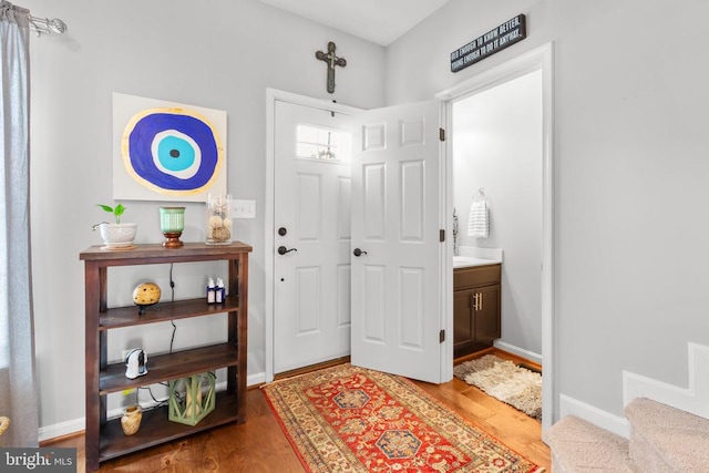 foyer with wood finished floors and baseboards