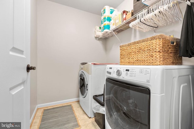 laundry area featuring light tile patterned floors, laundry area, independent washer and dryer, and baseboards