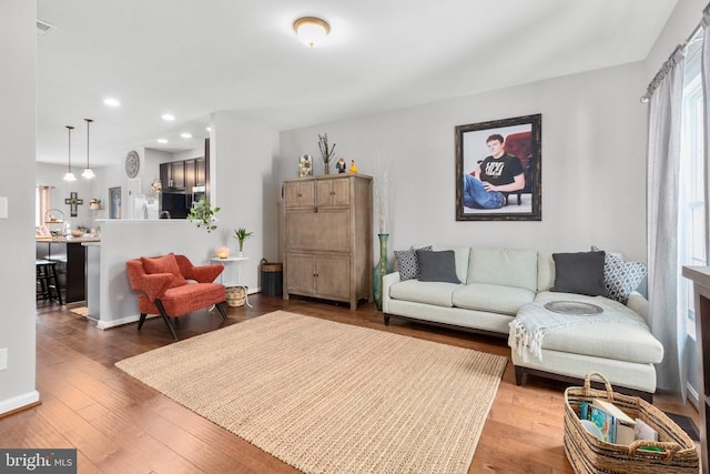 living room with baseboards, hardwood / wood-style floors, and recessed lighting