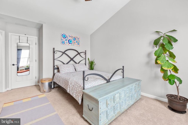 bedroom with light carpet, vaulted ceiling, and baseboards