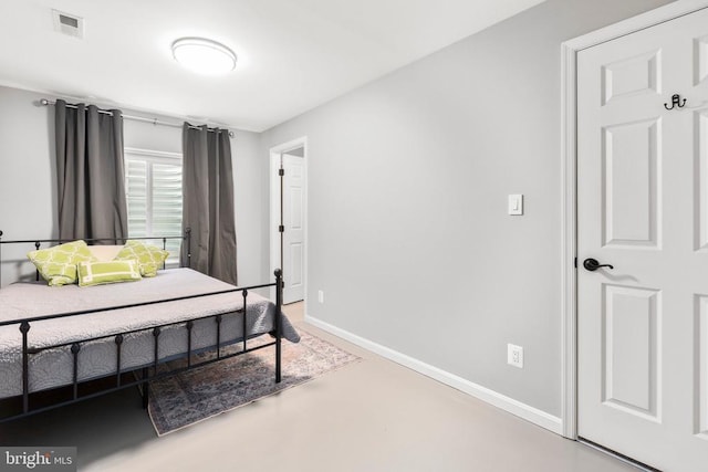 bedroom featuring visible vents, finished concrete floors, and baseboards