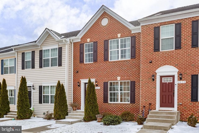 townhome / multi-family property with entry steps and brick siding