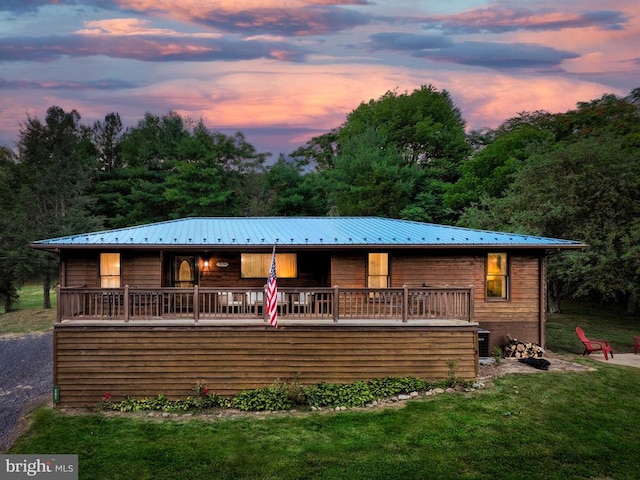 view of front of home with a wooden deck and a yard