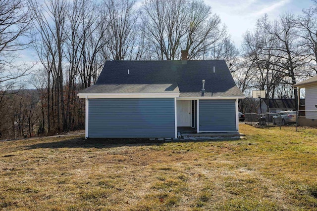 rear view of property featuring a lawn