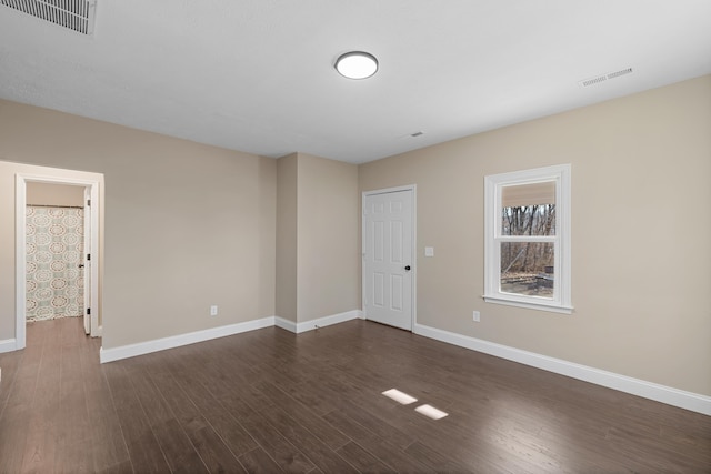 unfurnished room with dark hardwood / wood-style flooring