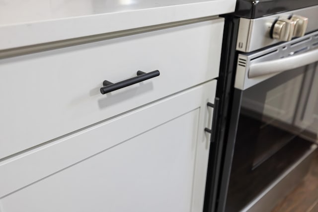 interior details featuring white cabinetry and gas range