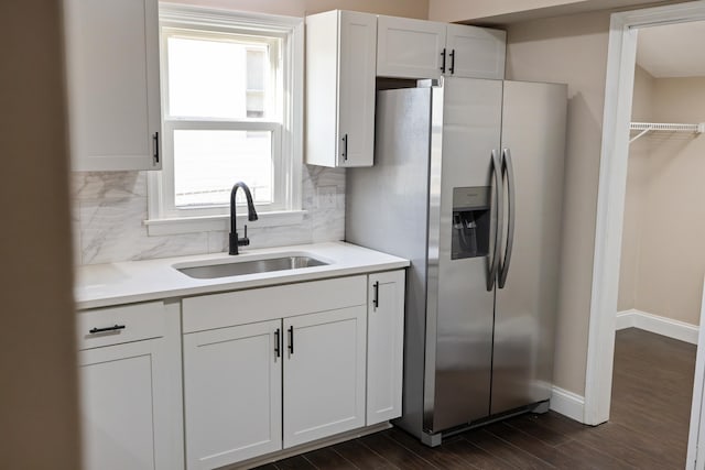 kitchen with sink, backsplash, white cabinets, dark hardwood / wood-style flooring, and stainless steel refrigerator with ice dispenser