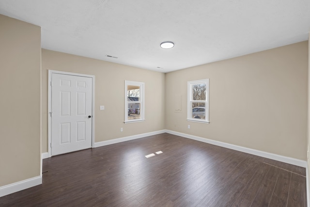 spare room featuring dark wood-type flooring