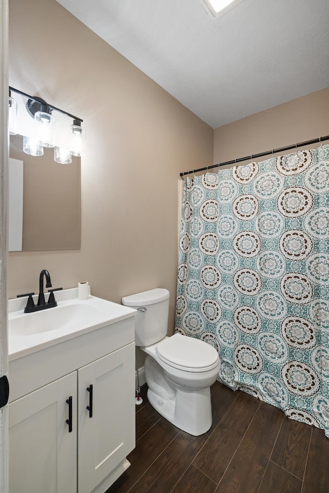 bathroom with wood-type flooring, vanity, and toilet