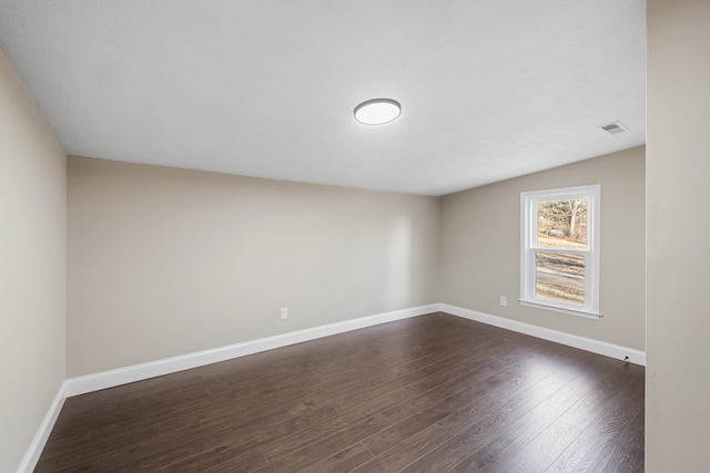 unfurnished room with dark hardwood / wood-style flooring