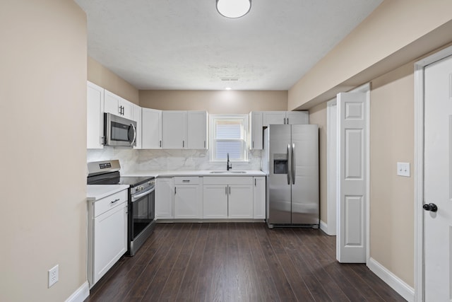 kitchen featuring sink, backsplash, stainless steel appliances, dark hardwood / wood-style floors, and white cabinets