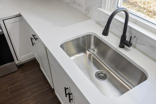 interior details featuring range with electric cooktop, sink, dark wood-type flooring, and white cabinets