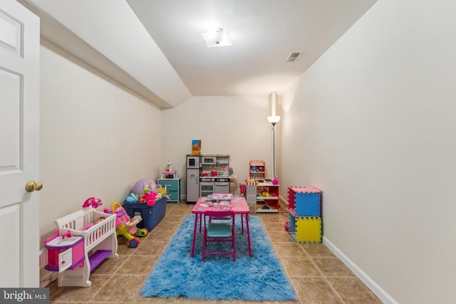 game room featuring vaulted ceiling, visible vents, tile patterned floors, and baseboards