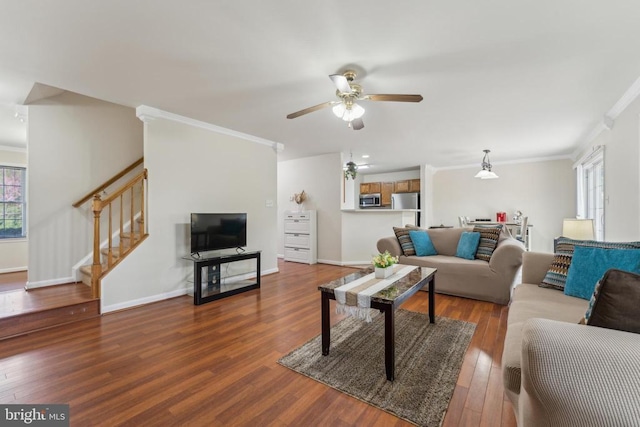 living room featuring crown molding, stairs, wood finished floors, ceiling fan, and baseboards
