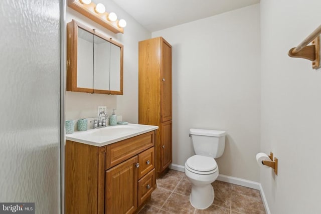 bathroom featuring tile patterned floors, baseboards, vanity, and toilet