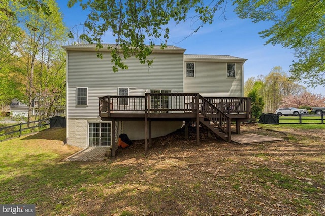 back of house featuring a lawn, fence, and a deck
