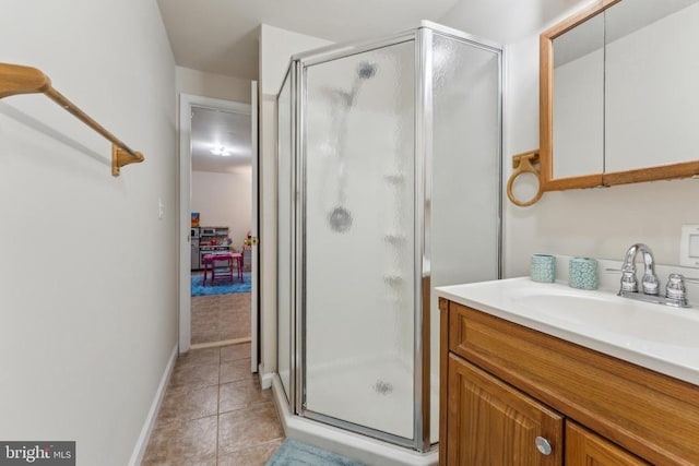 full bath featuring baseboards, a shower stall, tile patterned flooring, and vanity