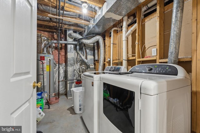 clothes washing area featuring separate washer and dryer, water heater, and laundry area